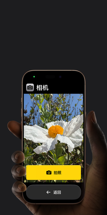 iPhone?16?Pro 屏幕顯示精簡的相機 app 界面，包括取景畫面中的白色花朵、“拍照”按鈕及其下方的“返回”按鈕。