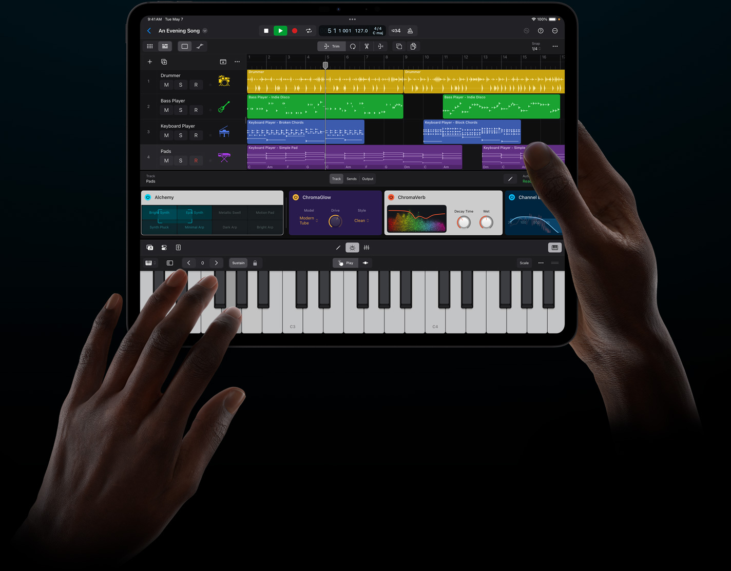 一雙手拿著一部 iPad Pro，以觸控方式在 iPad 版 Logic Pro 中演奏虛擬樂器。
